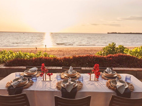 A dining table set for six overlooking the ocean.