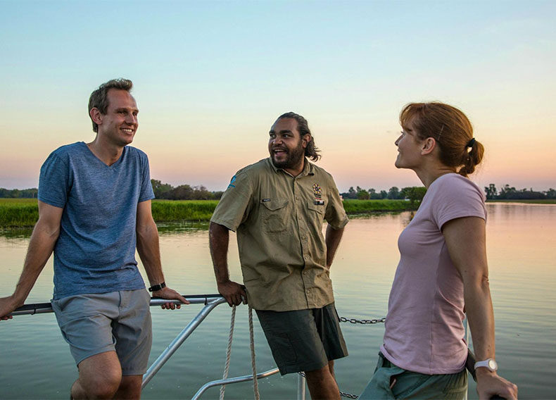 A park guide speaks to a couple on a boat.