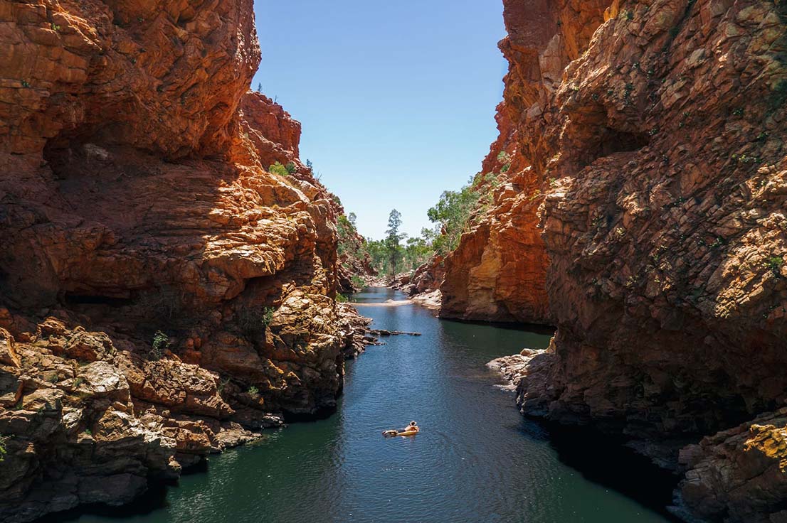 A man floating down Ellery Creek, which runs through a dramatic canyon.