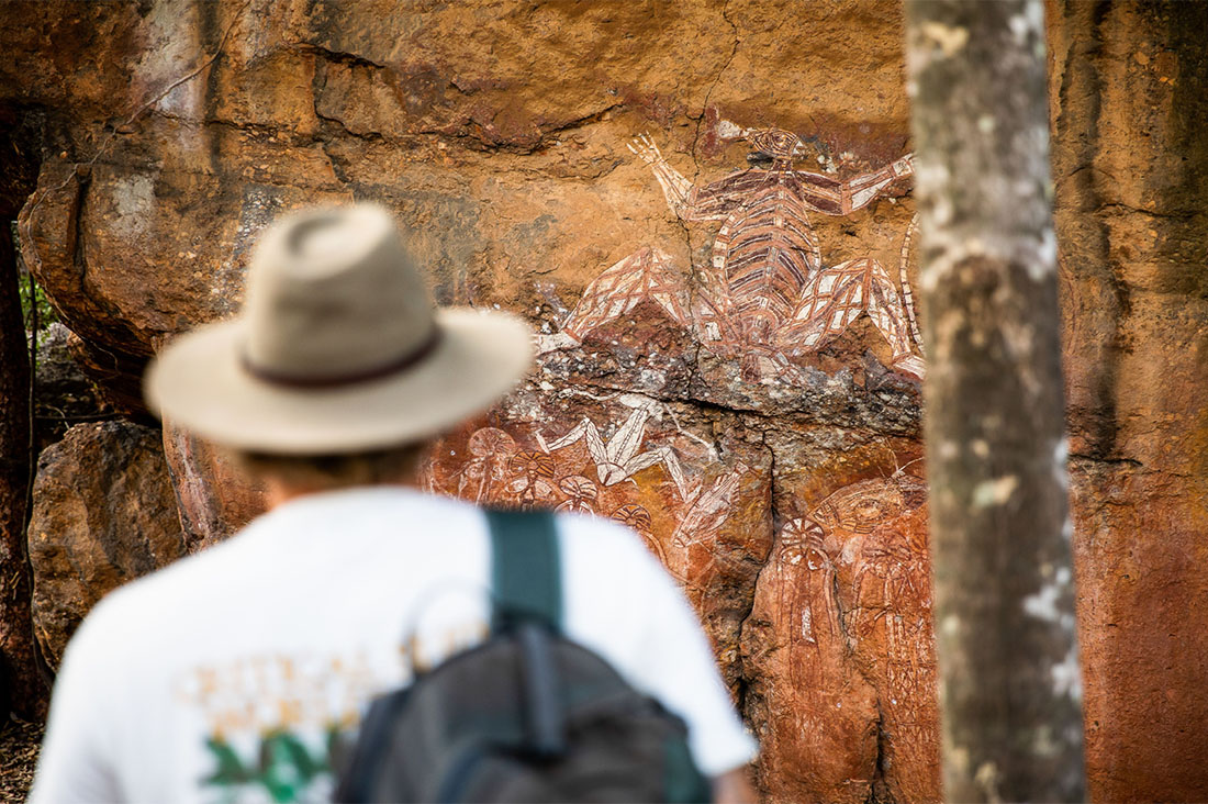 A man looks at ancient Aboriginal cave art.